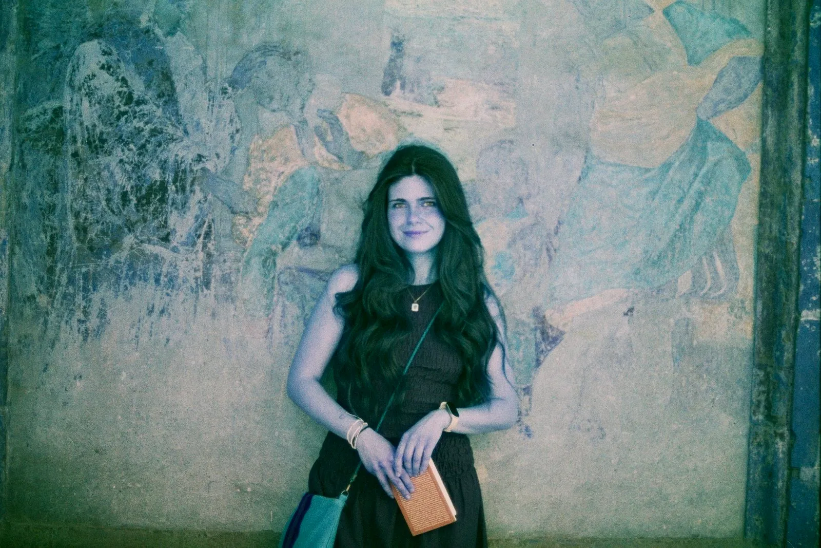 Una persona davanti a un affresco, con i colori virati verso l’azzurro